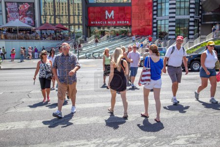 Photo for Las Vegas, USA - June 16, 2012: people hurry to cross the street the Strip in Las Vegas, USA. They cross the street at a pedestrian crossing. - Royalty Free Image