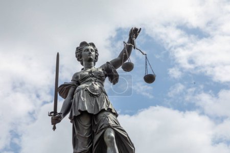 Téléchargez les photos : Francfort, Allemagne - 24 mai 2023 : Dame justice à Francfort avec épée et ciel nuageux comme symbole de la justice et du droit - en image libre de droit