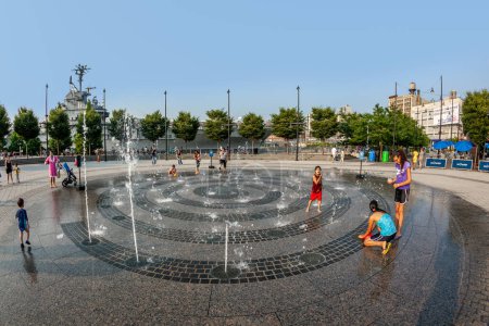 Photo for New York, USA - July 8, 2010: people in the public fountain area have a refreshing bath at the east harbor side in late afternoon in New York, USA. - Royalty Free Image