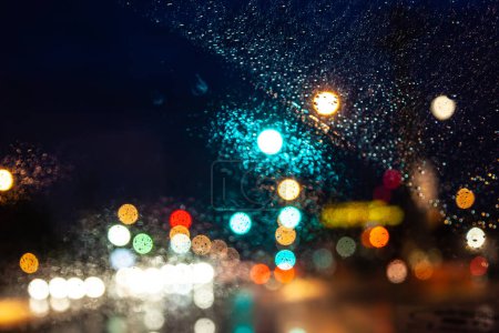 Photo for Traffic light with red arrow in storm  and dark rain clouds defocused as light symbols seen from car windshield in the ,USA - Royalty Free Image