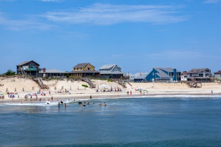 Photo for Nags Head, USA - July 18, 2010: people enjoy bathing in Nags Head, USA. Established in the 1830s as first tourist colony. The first oceanfront cottage was built here around 1855 by Dr. W.G. Pool. - Royalty Free Image