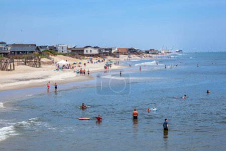 Photo for Nags Head, USA - July 18, 2010: people enjoy bathing in Nags Head, USA. Established in the 1830s as first tourist colony. The first oceanfront cottage was built here around 1855 by Dr. W.G. Pool. - Royalty Free Image