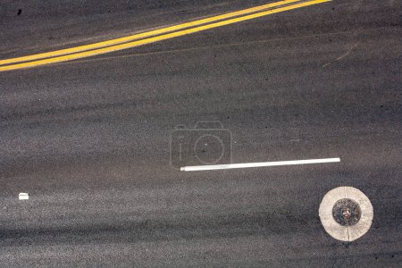 Téléchargez les photos : Ravin à rue grise avec médiane jaune comme symbole de la circulation - en image libre de droit