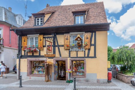 Photo for Ribeauville, France - June 23, 2023: A picturesque colorful street of half-timber buildings with shops and cafes in the village of Ribeauville, in the Alsace region. - Royalty Free Image
