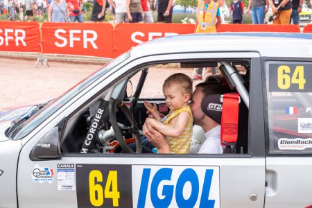 Téléchargez les photos : Geraldmer, France - 18 juin 2023 : Conducteur de rallye avec son enfant à la position des pilotes sur le chemin de l'accueil officiel du trophée de rallye geraldmer. - en image libre de droit