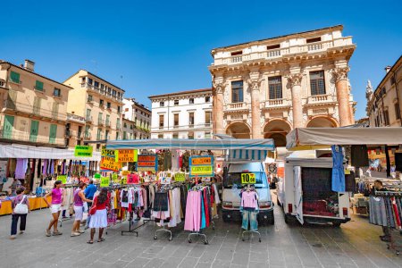 Foto de Vicenza, Italia - 4 de agosto de 2009: la gente va de compras al mercado en la Piazza del Signori en Vicenza, Italia. El palacio fue construido por el famoso arquitecto Andrea Palladio. - Imagen libre de derechos