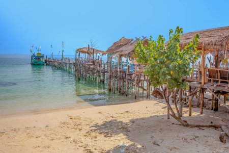 belle plage tropicale avec ancienne jetée en bois et cabanes à Koh Samet