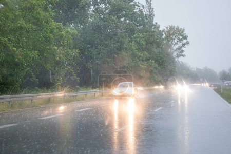 Téléchargez les photos : Vue limitée de la voiture sous forte pluie et tempête du point de vue des conducteurs comme symbole de la circulation par mauvais temps - en image libre de droit