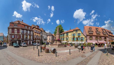 Foto de Ribeauville, Francia - 23 de junio de 2023: Una pintoresca calle colorida de edificios de media madera con tiendas y cafeterías en el pueblo de Ribeauville, en la región de Alsacia. - Imagen libre de derechos