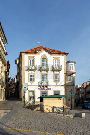 Foto de Chaves, Portugal - 2 de mayo de 2023: fachada histórica de la casa en Chaves en la plaza Santa Maria Maior con publicidad de audífonos - Audicao activa. - Imagen libre de derechos