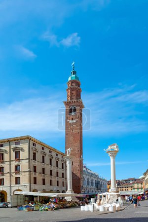 Foto de VICENZA, ITALIA - 4 de agosto de 2009: la gente camina por la Piazza del Signori en Vicenza, Italia. La torre fue construida por el famoso arquitecto Andrea Palladio
. - Imagen libre de derechos