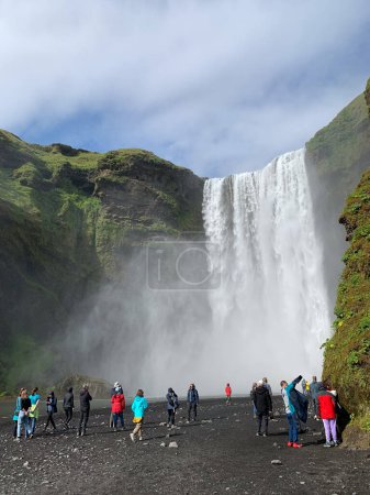 Photo for Skogafoss, Iceland -July 19, 2023: Tourists walking towards the Skogafoss waterfall in summer. - Royalty Free Image