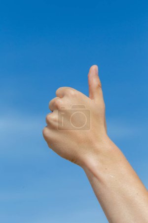 Photo for Thumbs up sign under clear blue sky - Royalty Free Image