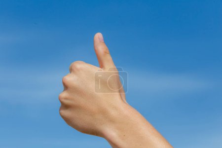 Téléchargez les photos : Pouce vers le haut signe sous le ciel bleu clair - en image libre de droit