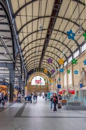 Foto de Wiesbaden, Alemania - 16 de agosto de 2023: la gente espera en la estación de tren la salida en la estación de tren clasicista de Wiesbaden, la copia más pequeña de la estación de tren de Frankfurt. - Imagen libre de derechos