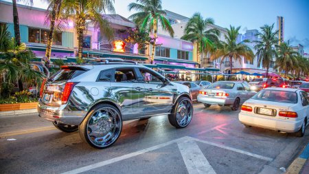 Photo for Miami Beach, USA - August 23, 2014: night view to ocean drive with art deco hotels and restaurants in the art deco district.and chrome car with big wheels. - Royalty Free Image
