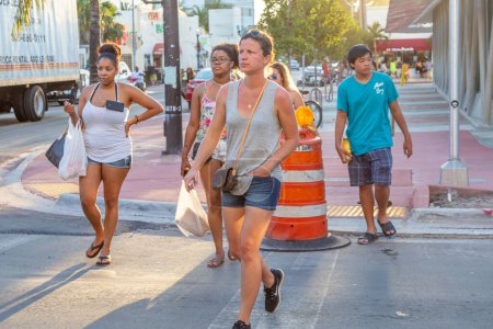Photo for Miami, USA - August 23, 2014: tourists  in the art deco district in South Beach, Miami, USA crossing a road. - Royalty Free Image