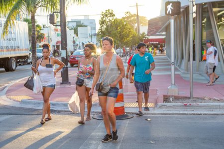 Foto de Miami, EE.UU. - 23 de agosto de 2014: turistas en el distrito art deco en South Beach, Miami, EE.UU. cruzando una carretera. - Imagen libre de derechos
