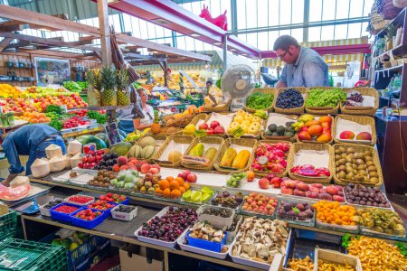 Photo for Frankfurt, Germany - August 9, 2014: man sells fresh vegetables and fruits in the Kleinmarkthalle - engl: small markethall - in Frankfurt. - Royalty Free Image