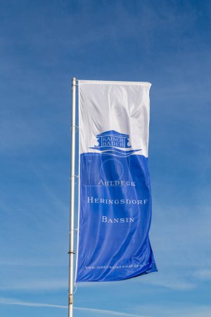 Téléchargez les photos : Ahlbeck, Allemagne - 17 avril 2014 : drapeau avec inscription Ahlbeck, Heringsdorf, Bensin - 3 Kaiserbaeder - engl : trois rois Espaces thermaux - flottement dans le vent. - en image libre de droit