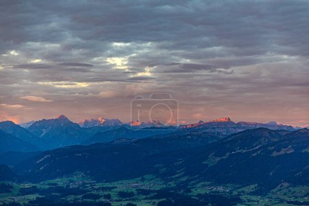 Téléchargez les photos : Lever de soleil vu du sommet de la montagne de Gruenten avec village de Rettenberg et panorama des Alpes, Allemagne - en image libre de droit