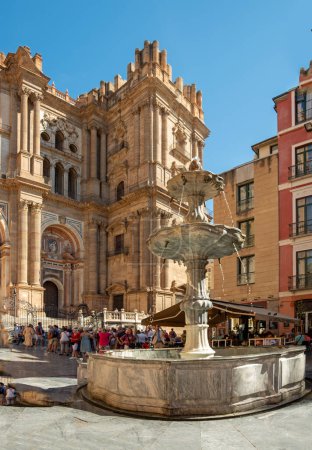 Photo for Malaga, Spain - September 28,2023: Facade of the Malaga Cathedral or Santa Iglesia Catedral Baslica de la Encarnacin, with a fountain and tourists in the town square in the foreground. - Royalty Free Image