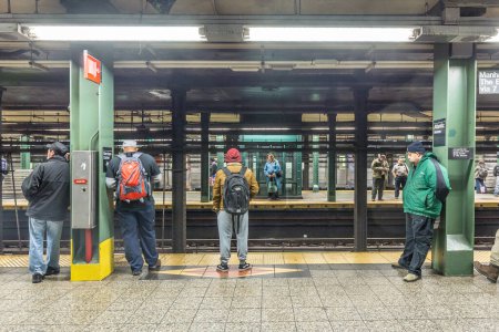 Téléchargez les photos : New York, États-Unis - 20 octobre 2015 : Les gens attendent à la station de métro Wall street à New York. Avec 1,75 milliard d'usagers annuels, NYC Subway est le 7ème métro le plus achalandé au monde
. - en image libre de droit