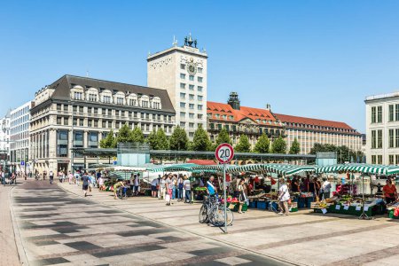 Téléchargez les photos : Leipzig, Allemagne - 4 août 2015 : les gens aiment faire du shopping au marché des fermiers en plein air sur la place du marché à Leipzig avec la vieille mairie en arrière-plan. - en image libre de droit