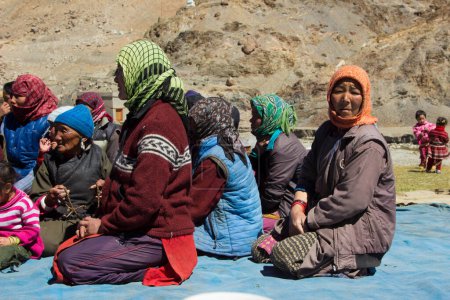 Foto de Leh, India - 18 de septiembre de 2014: retrato de aldeanos sentados en trajes tradicionales en el lugar de encuentro cerca de Leh en la provincia de Ladakh en la India. - Imagen libre de derechos