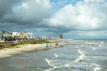 Photo for Galveston, USA - October 29, 2023: people enjoy the beautiful sandy beach at the gulf of Mexico at the island of Galveston with dramatic beautiful sky in Texas, USA. - Royalty Free Image