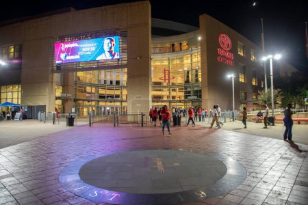Foto de Houston, Estados Unidos - 20 de octubre de 2023: vista nocturna del centro de Toyota en Houston. La gente se apresura a entrar para unirse al partido de baloncesto Houston Rockets. - Imagen libre de derechos