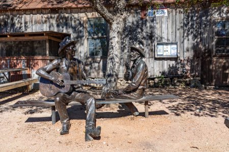 Foto de Luckenbach, Estados Unidos - 2 de noviembre de 2023: Jerry Jeff Walkers Hondo Crouch Estatua de un vaquero tocando la guitarra Desvelada en Luckenbach, Texas. - Imagen libre de derechos