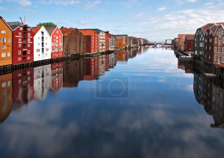 Foto de Amplia vista panorámica de antiguas casas de madera de colores con reflejos en el río Nidelva en el distrito de Brygge en Trondheim, Noruega - Imagen libre de derechos