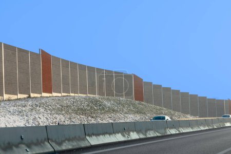 Téléchargez les photos : Lever de soleil sur l'autoroute avec des voitures et un mur de protection contre le bruit en arrière-plan en Allemagne - en image libre de droit