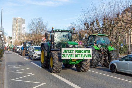 Photo for Wiesbaden, Germany - January 8, 2024: farmer with their tractors demonstrate for cutting down the price for diesel fuel and against the german government with poster enough is enought - Jetzt reichts zu viel ist zuviel - Royalty Free Image