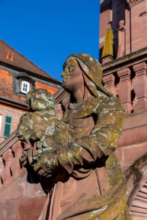 Foto de Amorbach, Alemania - 27 de enero de 2024: estatua de piedra arenisca de la virgen María con el niño en la iglesia de la Abadía de Amorbach en Baviera, Alemania. - Imagen libre de derechos