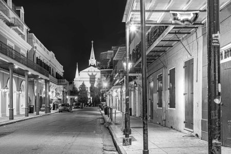 Foto de Nueva Orleans; Estados Unidos - 24 de octubre de 2023: Pubs and bars with neon lights in the French Quarter, downtown New Orleans by night with shadow of ghost at church wall - Imagen libre de derechos