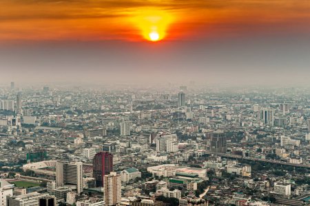 Antenne der Skyline von Bangkok zum Fluss Chao Phraya im Sonnenuntergang mit dem Smog der Luftverschmutzung in Bangkok, Thailand