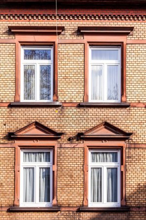 Téléchargez les photos : Façade de maison classique avec mur de briques et fenêtres modernes - en image libre de droit