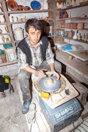 Foto de Anspach, Alemania - 27 de marzo de 2011: un alfarero demuestra la fabricación de cerámica con una mesa giratoria y barro de cerámica. - Imagen libre de derechos