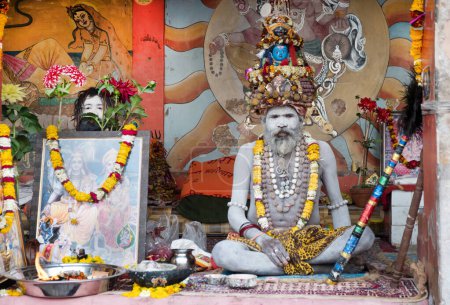 Téléchargez les photos : Varanasi, Inde - 24 février 2024 : vieux sadu peint en frêne blanc médite une arche de l'auberge pour les hindous religieux à Varanasi est aumônes de collecte. - en image libre de droit