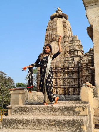 Photo for Raknapur, India - March 1, 2024: woman poses in front of the Jain Ranakpur Temple in Pali, Rajasthan.  This temple is famous for experimental love making scenes and erotic practices on the panels of temple walls. - Royalty Free Image