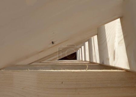 detail of wooden roof construction with background of depth of field and shadow as background and symbol of roof construction