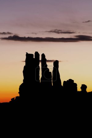 Sunrise behind Monument Valley's spires during a Navajo excursion, all formed by millions of years of erosion from wind and rain.
