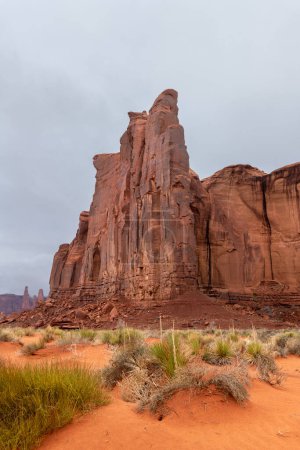 Large mountain along the side of Monument Valley's scenic park during a cloudy day shows the rock patterns, generally made of sandstone, moenkopi and or shinarump rock.
