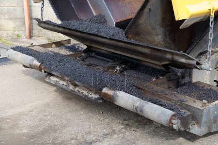 Téléchargez les photos : Finisseur de pavé, finisseur d'asphalte ou machine à paver plaçant une couche d'asphalte. Repavage - en image libre de droit