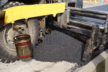 Foto de Finalizador de pavimentadora, finalizador de asfalto o máquina de pavimentación colocando una capa de asfalto. Repavimentación - Imagen libre de derechos
