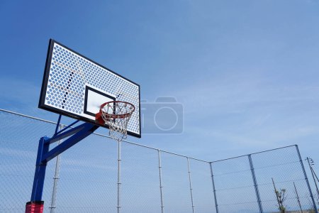 Téléchargez les photos : Basketball cerceau sur un terrain extérieur vide sur un ciel bleu. - en image libre de droit