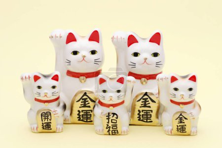 Photo for Japanese lucky cat on yellow background, Japanese word of this photography means "better fortune, blessing, economic fortune" - Royalty Free Image
