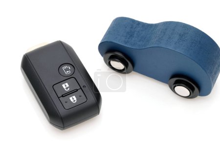 Foto de Control remoto de la llave negra del coche y pequeño coche de juguete sobre fondo blanco - Imagen libre de derechos